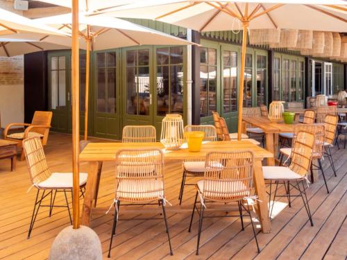 Photo d'une terrasse en bois avec des tables, des chaises et des parasols